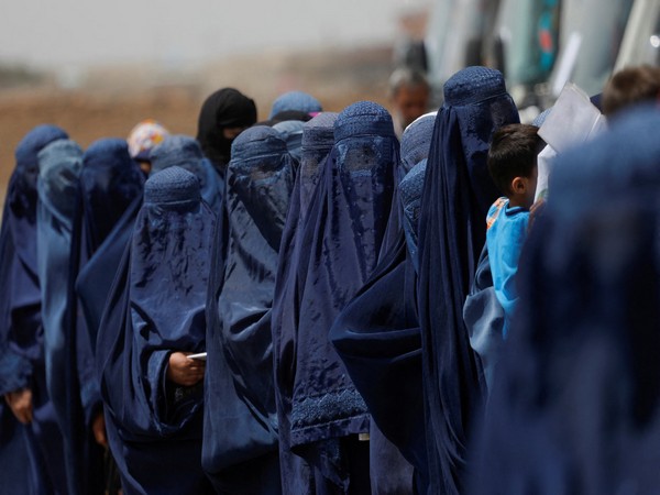 Afghan women in burqas stand in line as Taliban enforces strict dress code rules (Source: Reuters)
