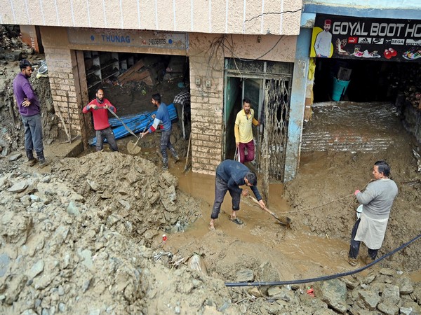 Shopkeepers remove the debris after a cloudburst, at Thunag in Mandi (Photo/ANI)