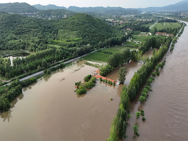 A drone view shows flooded farmlands next to the overflowing Chao river, following heavy rainfall in Miyun district of Beijing (Image/Reuters)