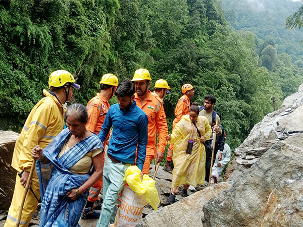 NDRF and SDRF personnel assist people moving through blocked route of Kedarnath Dham (Image/ANI)