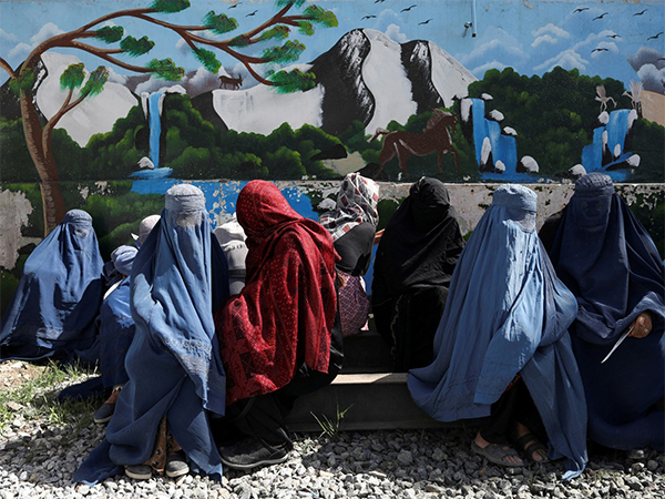 Afghan women wait to receive food packages distributed by a Saudi Arabian humanitarian aid group at a Kabul distribution center (File Photo/Reuters)