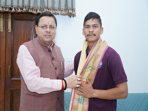 Uttarakhand Chief Minister Pushkar Singh Dhami meets Champawat resident Virendra Singh Samant. (Photo/ANI)