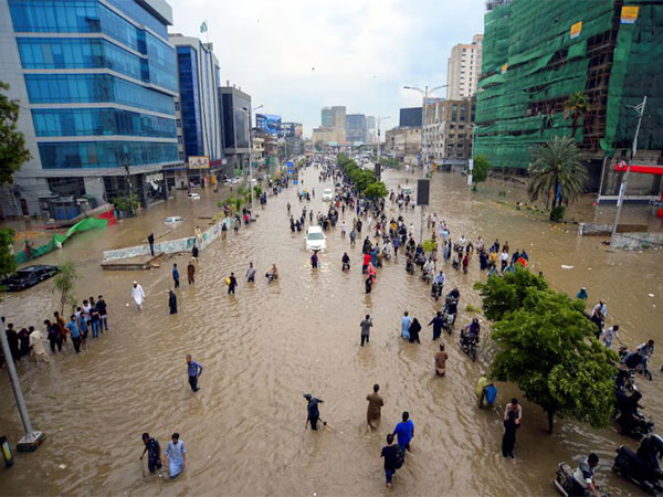 People navigate a waterlogged road following heavy monsoon rains in Karachi, Pakistan (Photo/Reuters)