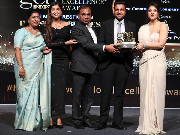 On stage at the Global Excellence Awards 2025, the Agarwal family--Sanjay Agarwal, Vaibhav, Shalini, and Simran--accepts the Best Construction Company in North India award from Kajol Devgan