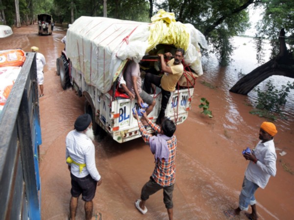 People receive relief material amid flood situation in Punjab (Photo/ANI)