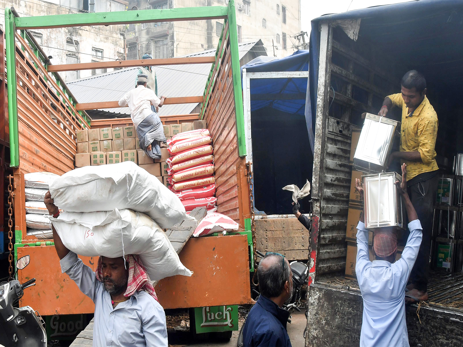 Labourers load the sacks of food items to a truck in a wholesale market (Photo/ANI)