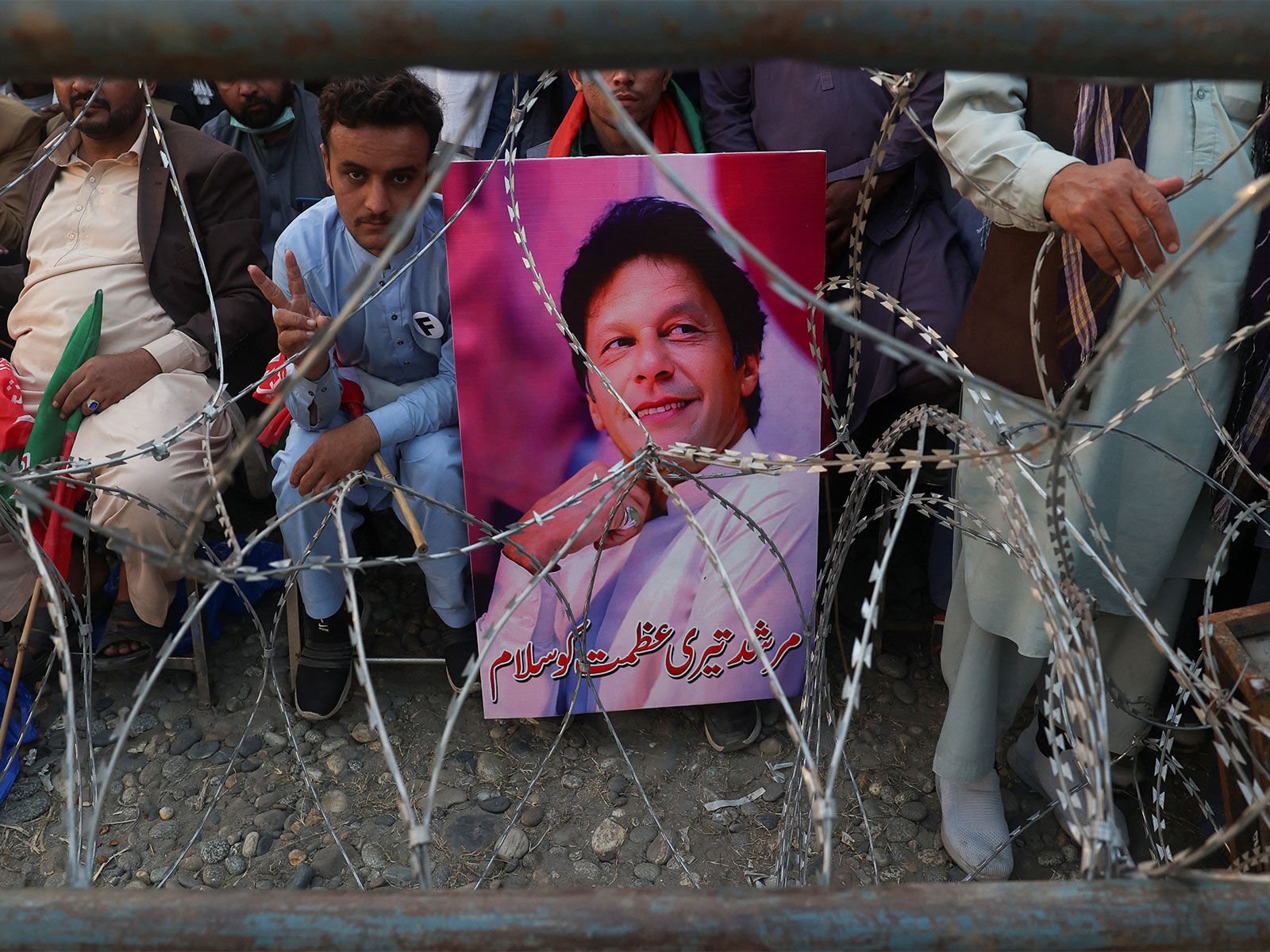 A supporter of jailed former Pakistani Prime Minister Imran Khan's party, the Pakistan Tehreek-e-Insaf holds his poster (Image/Reuters)