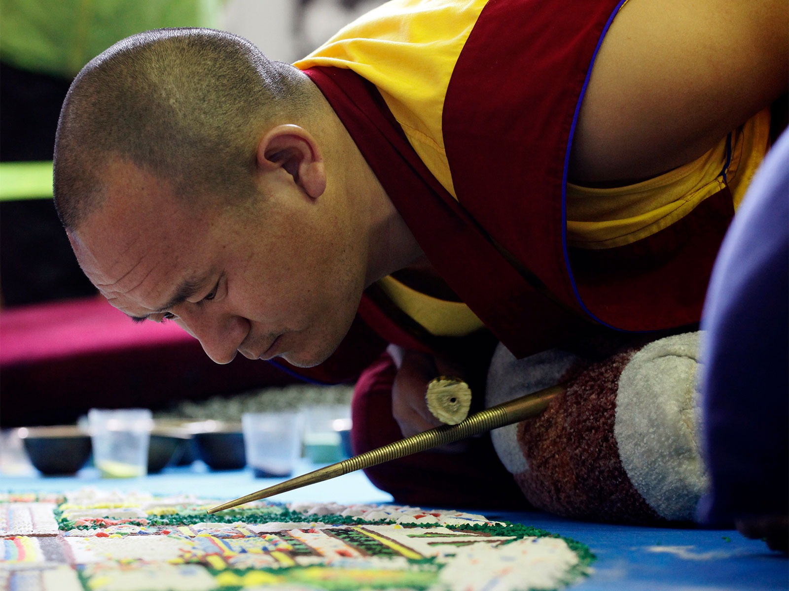 A Buddhist monk of the Gyudmed Tantric Monastery creates a sand Mandala, a religious diagram, in the Kyzyl town (Photo/Reuters)