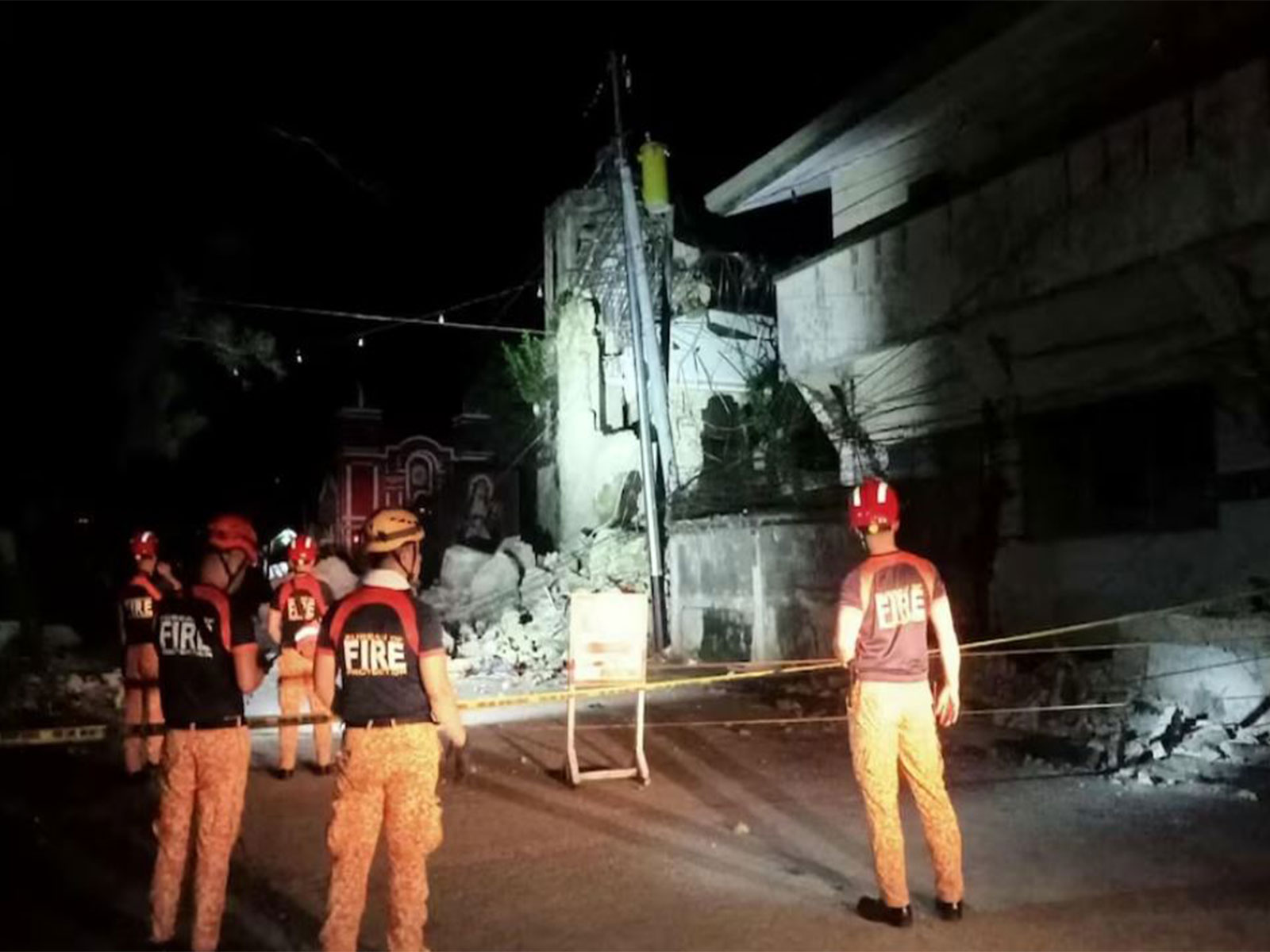 Rescue personnel stand in front of a damaged structure following a 6.9-magnitude earthquake, in Daanbantayan, Cebu Province, Philippines (Photo/ Reuters)