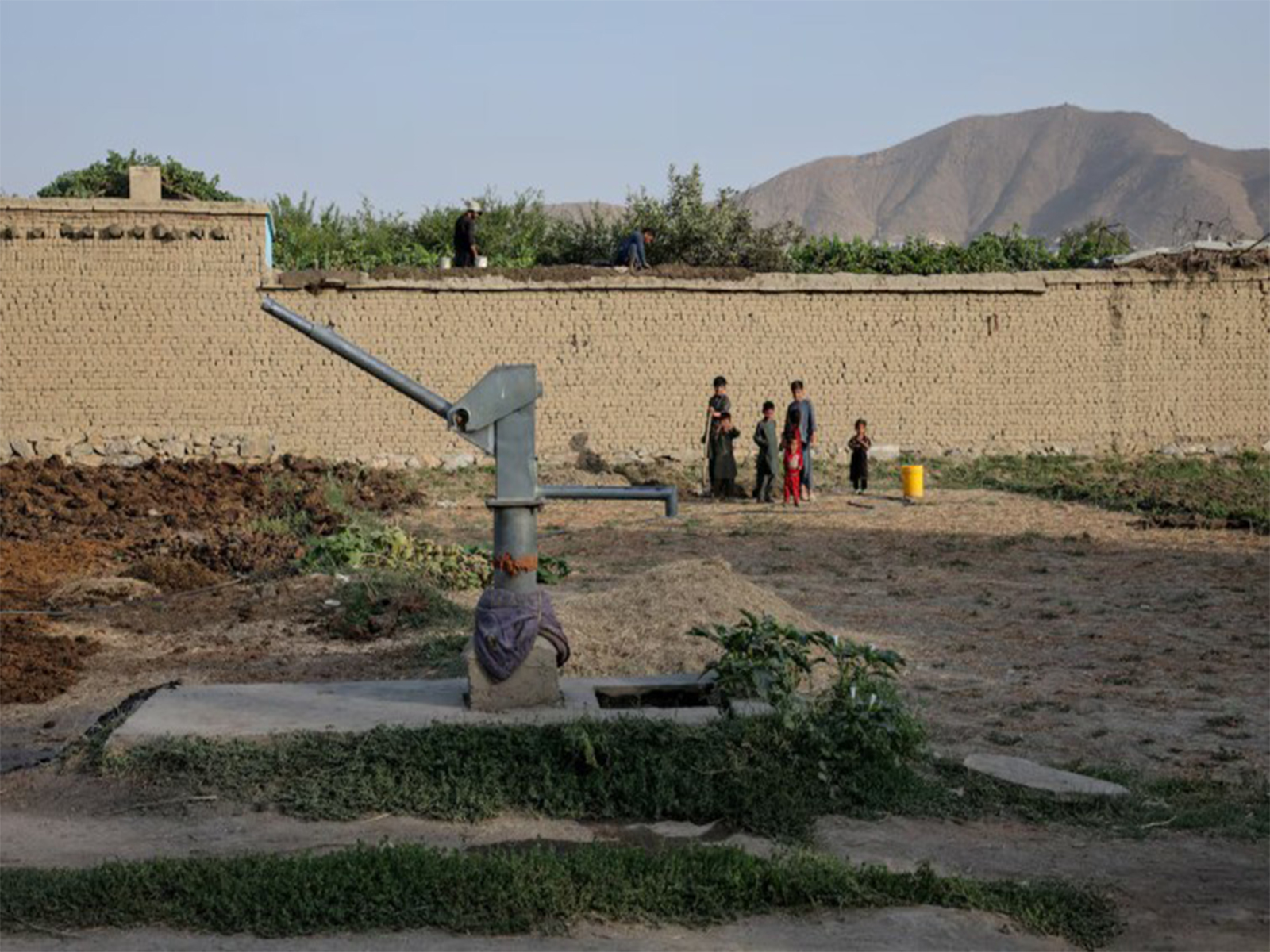 Children stand beside a dried-up hand pump amid a worsening water crisis in Kabul, Afghanistan. (File Photo/Reuters)