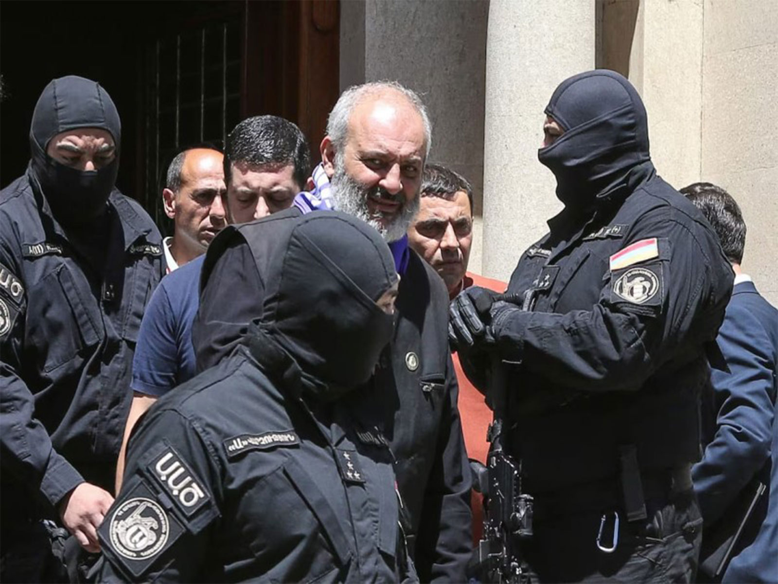 Armed security personnel escort a cleric under detention amid heightened tensions between Armenia's government and the national church. (File Photo/Reuters)