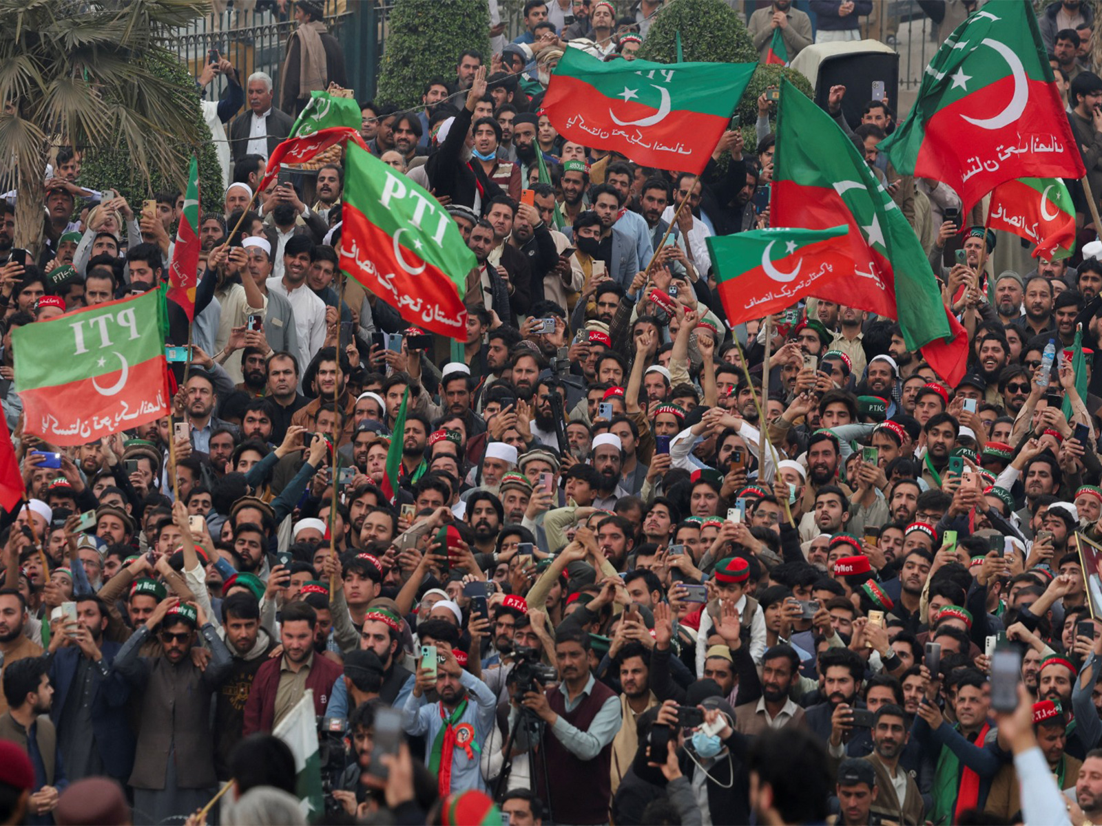 Supporters of Imran Khan's PTI wave flags during a protest demanding free and fair election results, in Peshawar, Pakistan. (File Photo/Reuters)