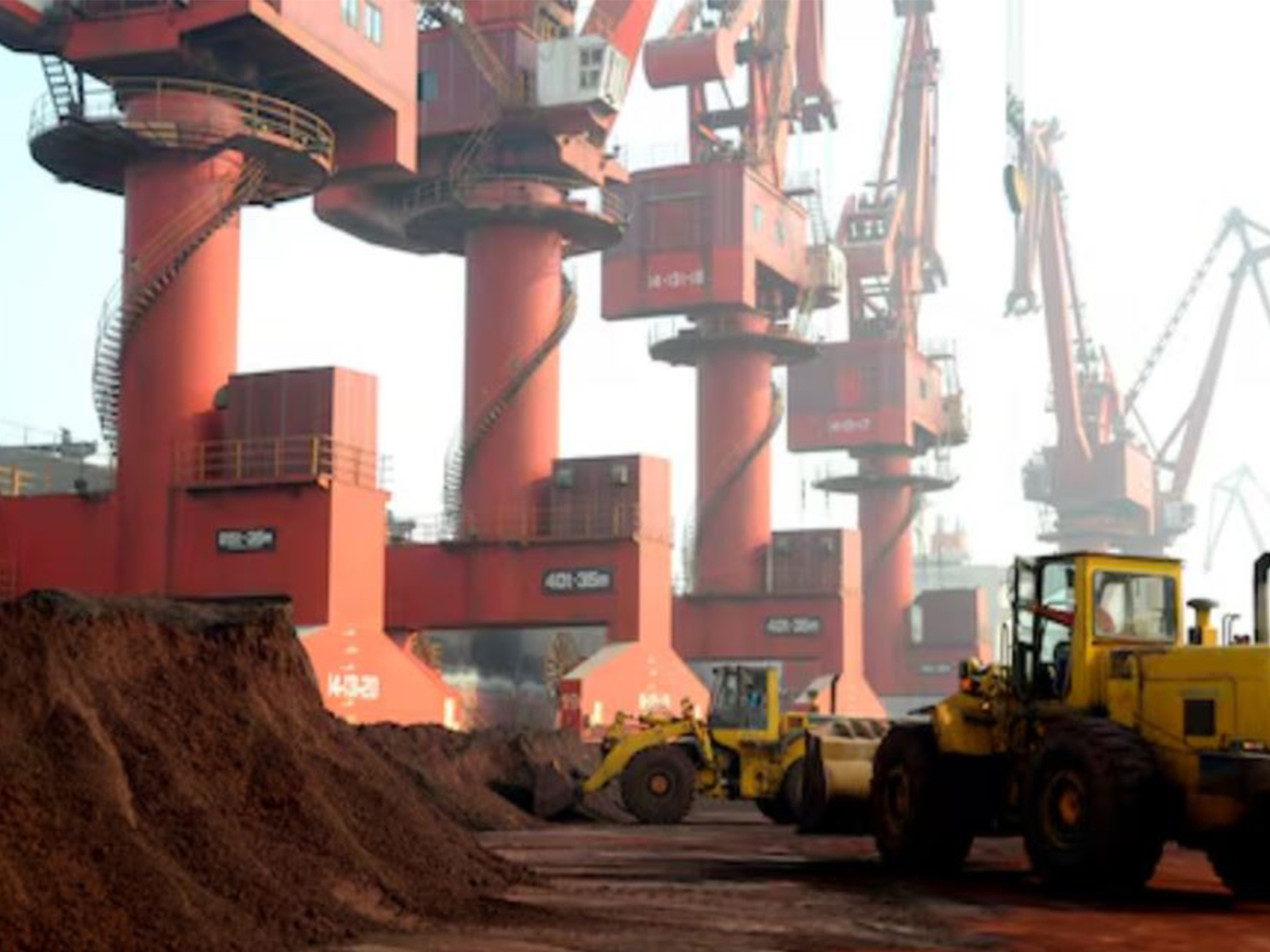 Workers transport soil containing rare earth elements for export at a port in Lianyungang, Jiangsu province (Photo/Reuters)