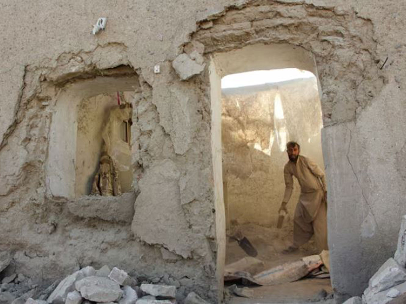 A man clears debris from his house damaged during Pakistani airstrike in Afghanistan (Photo/Reuters)