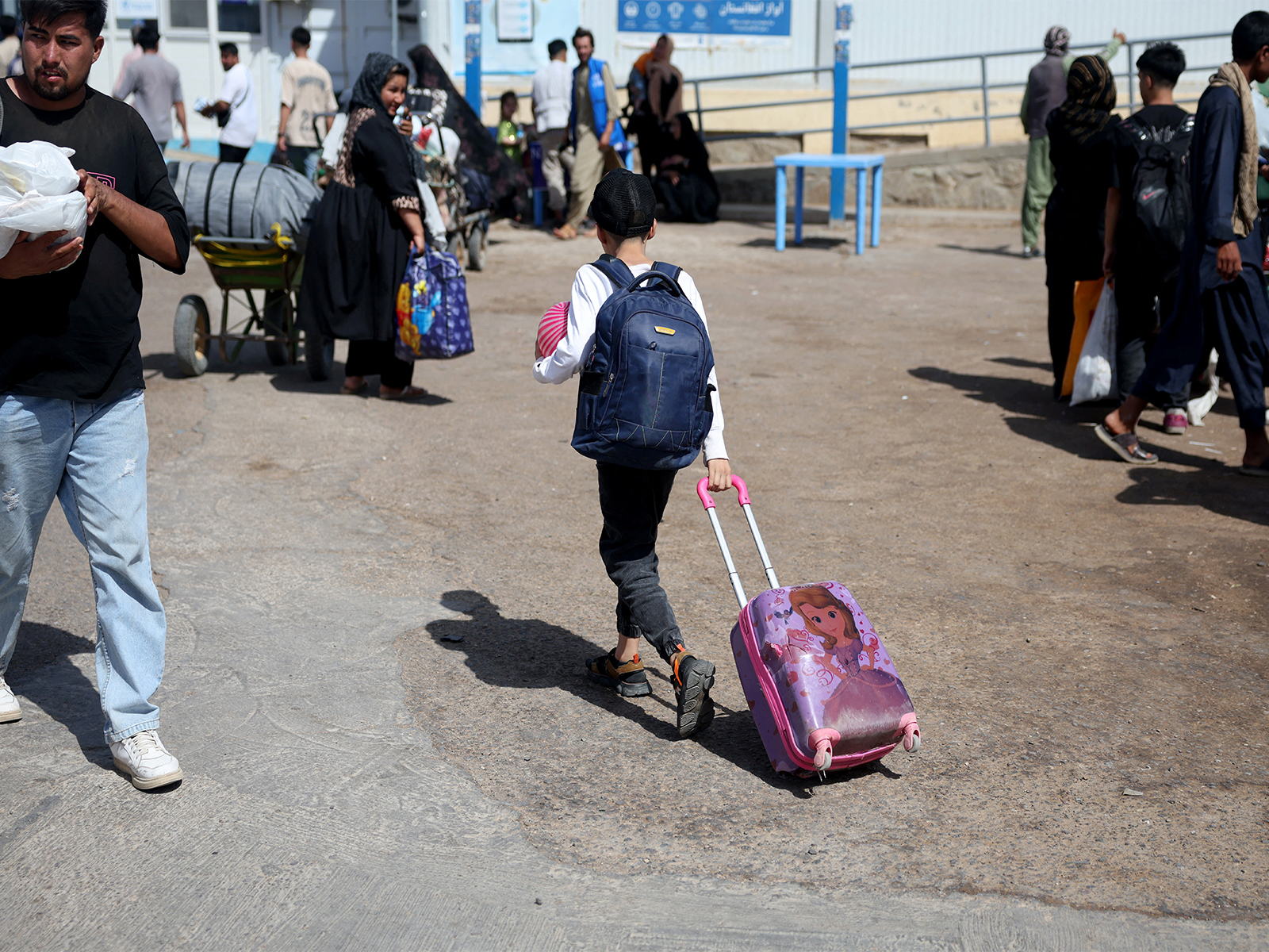 An Afghan boy deported from Iran pulls a rolling suitcase at a camp for returning migrants near the Islam Qala border crossing (Photo/Reuters)