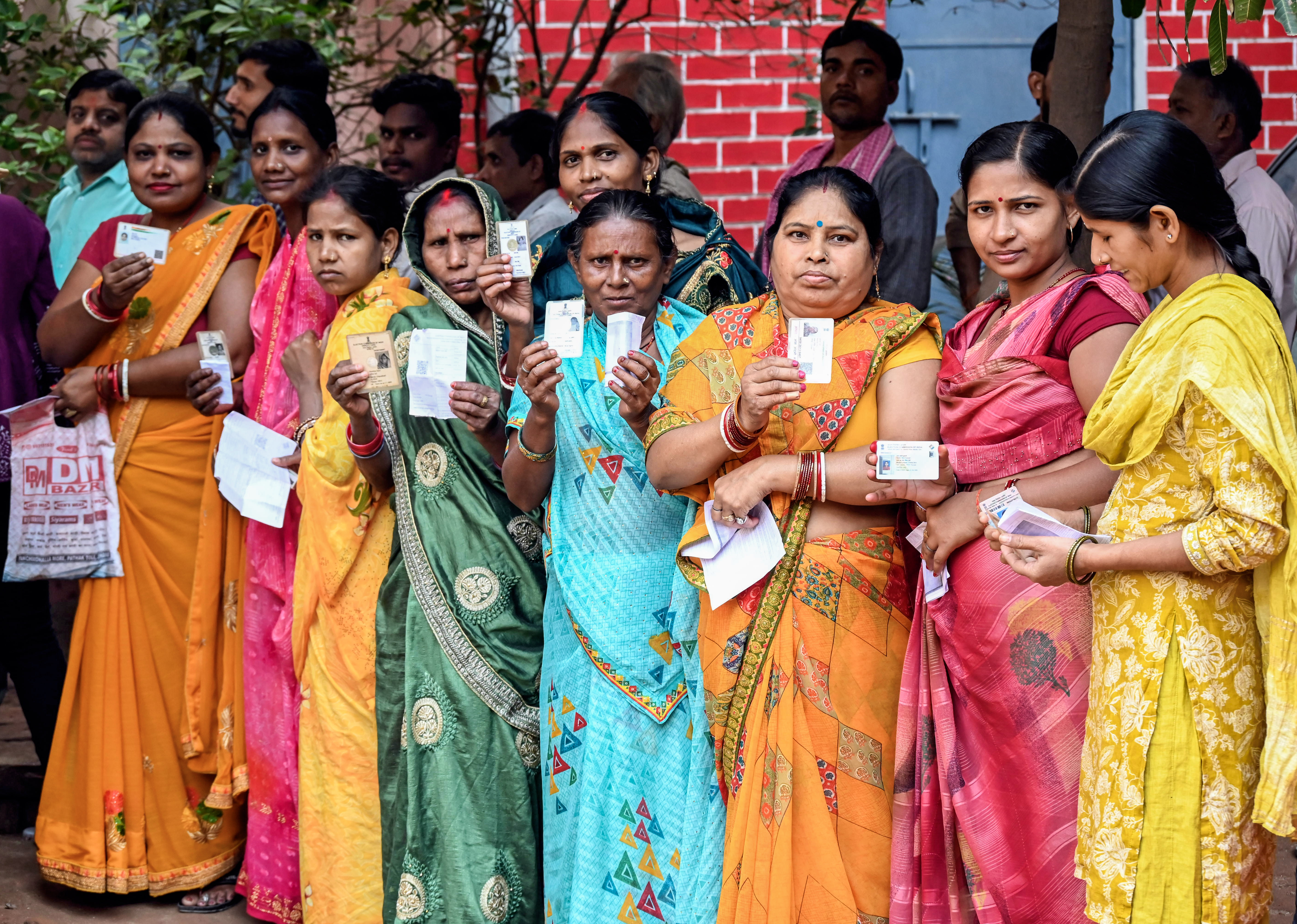 Women voters wait in a queue to cast their vote for the second phase of the Bihar assembly election, in Jahanabad