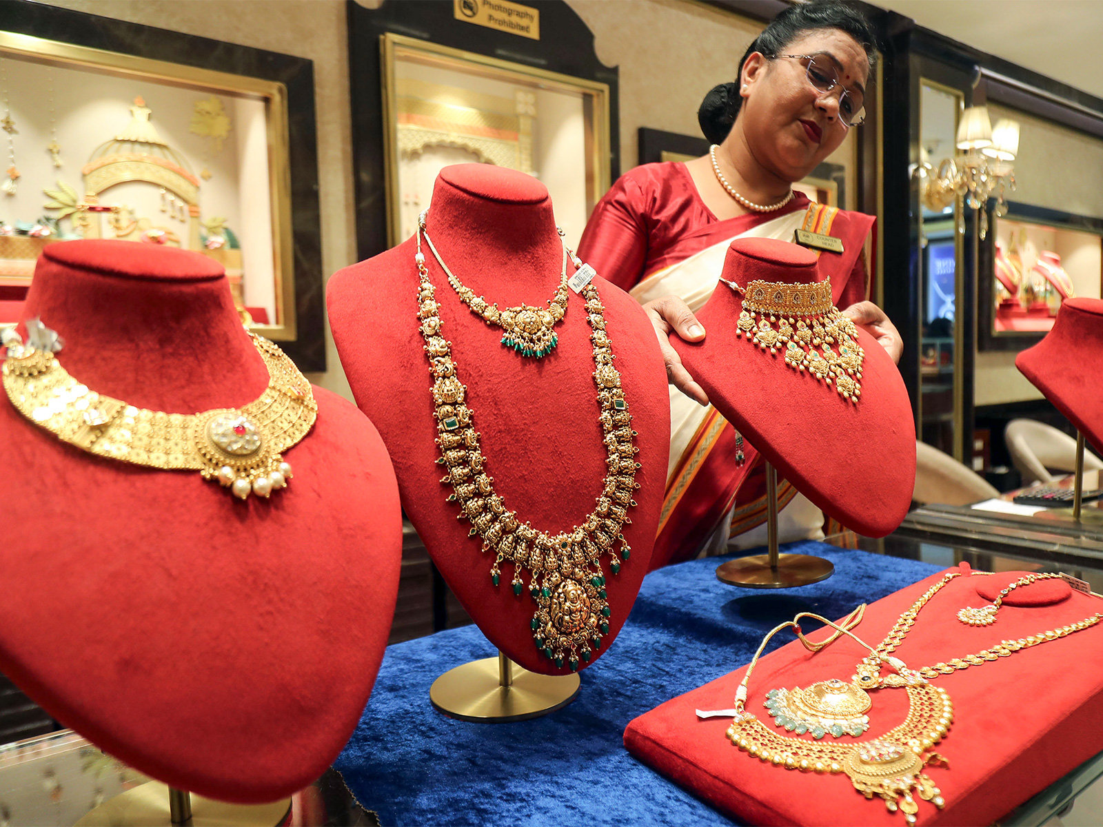 A saleswoman with a gold necklace at a jewellery shop (Photo/ANI)