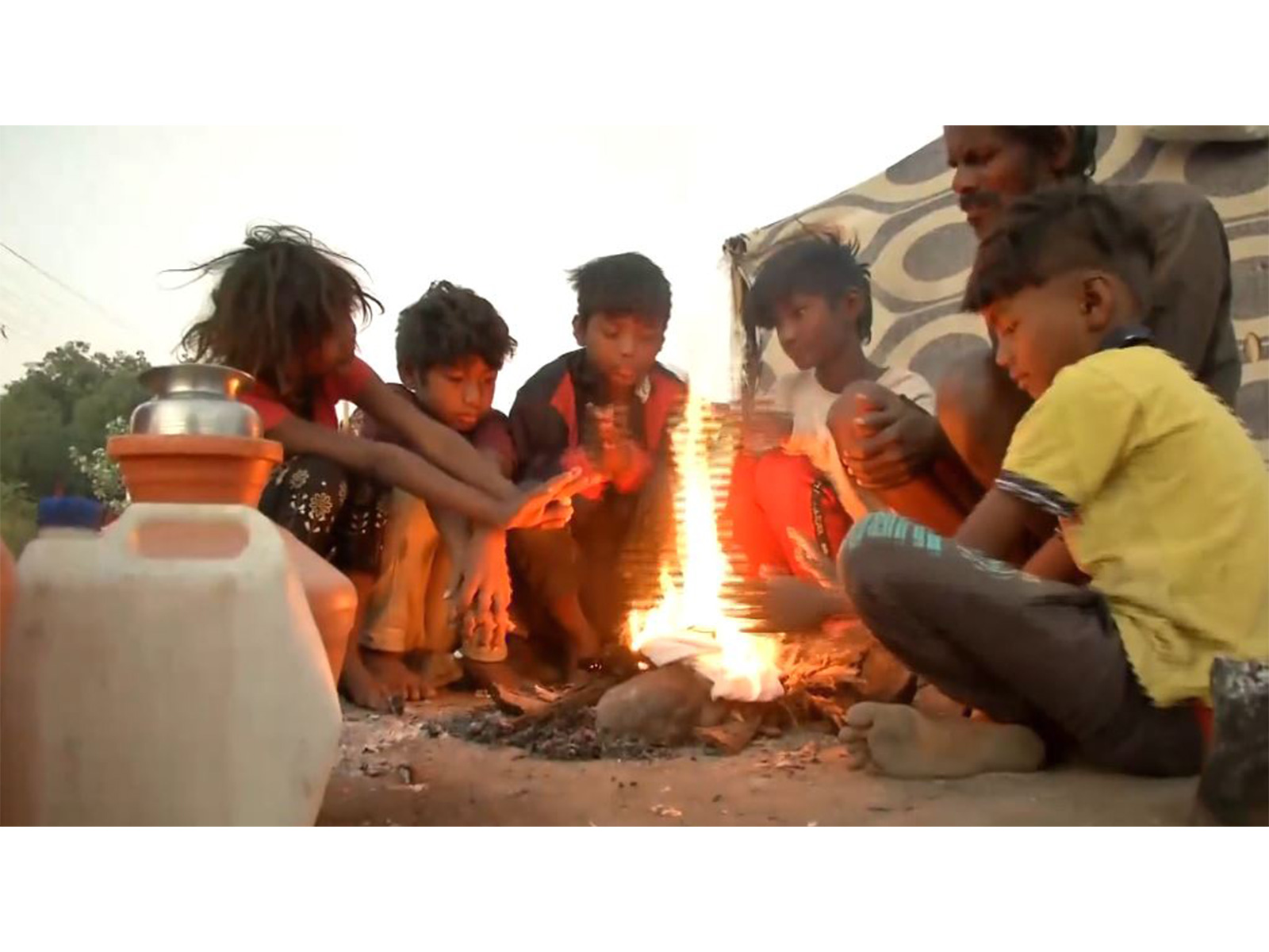 Children sit across fire to keep themselves warm (Photo/ANI)