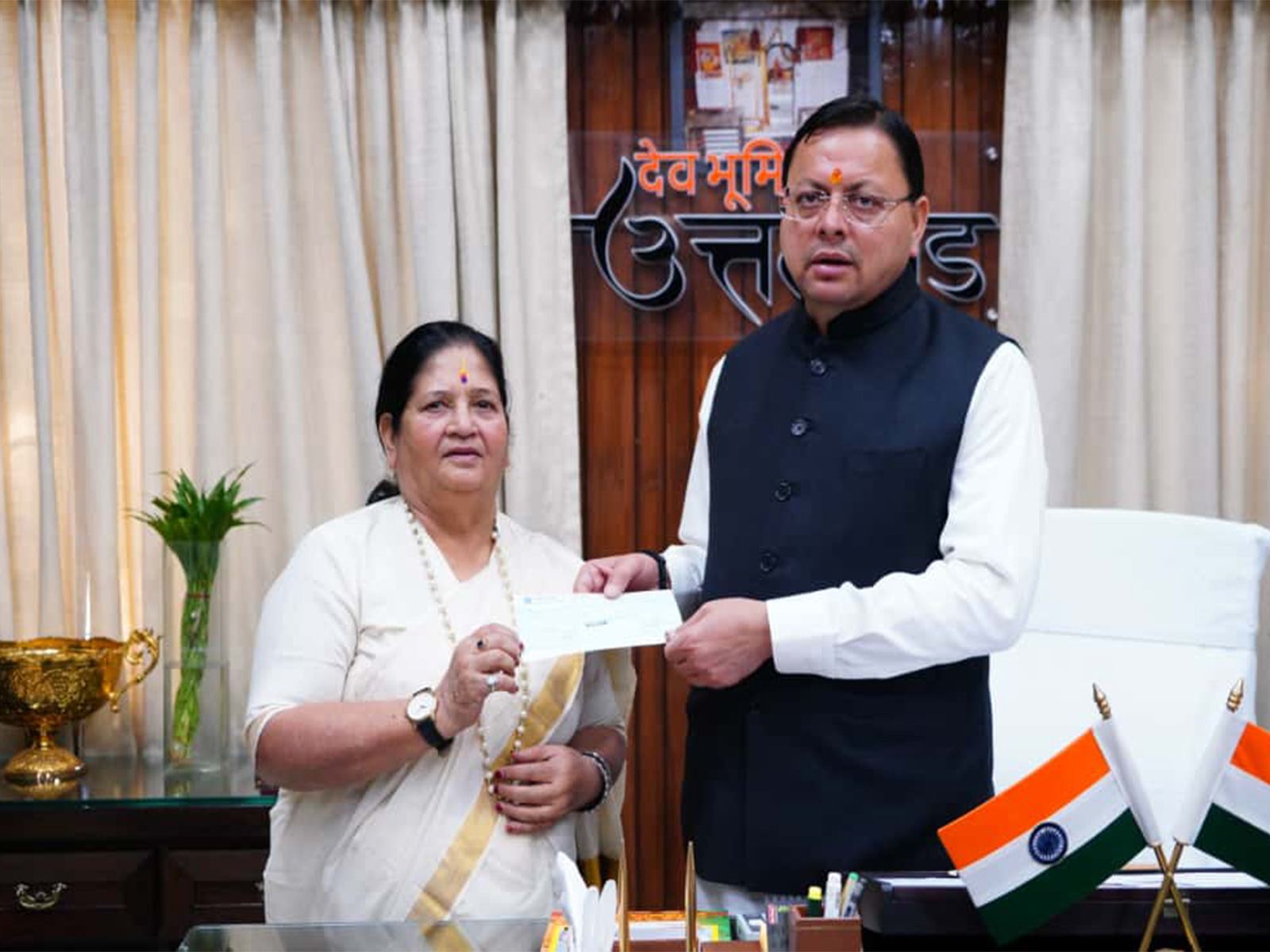 On Bachendri Pal's behalf Vice Chairperson of State Women's Entrepreneurship Council Vinod Uniyal handed over ₹10 lakh cheque to CM Dhami (Photo/ANI)