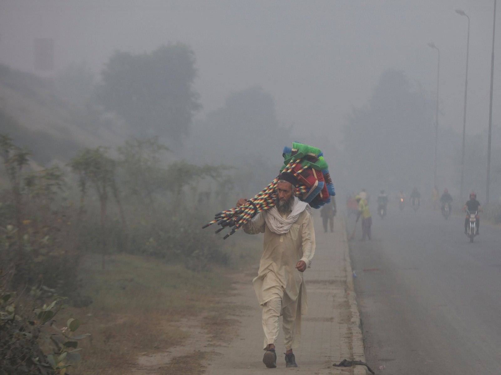 A man walks amid pollution and smoke in Lahore (Photo/Reuters)
