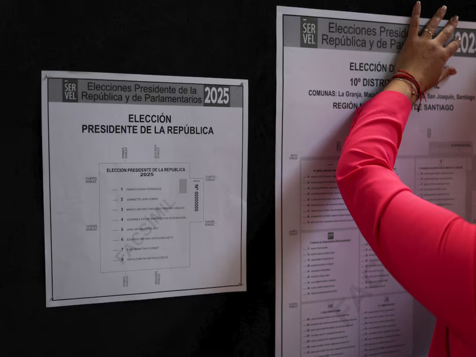A worker posts election information at a polling station in Santiago, Chile. (File Photo/Reuters)