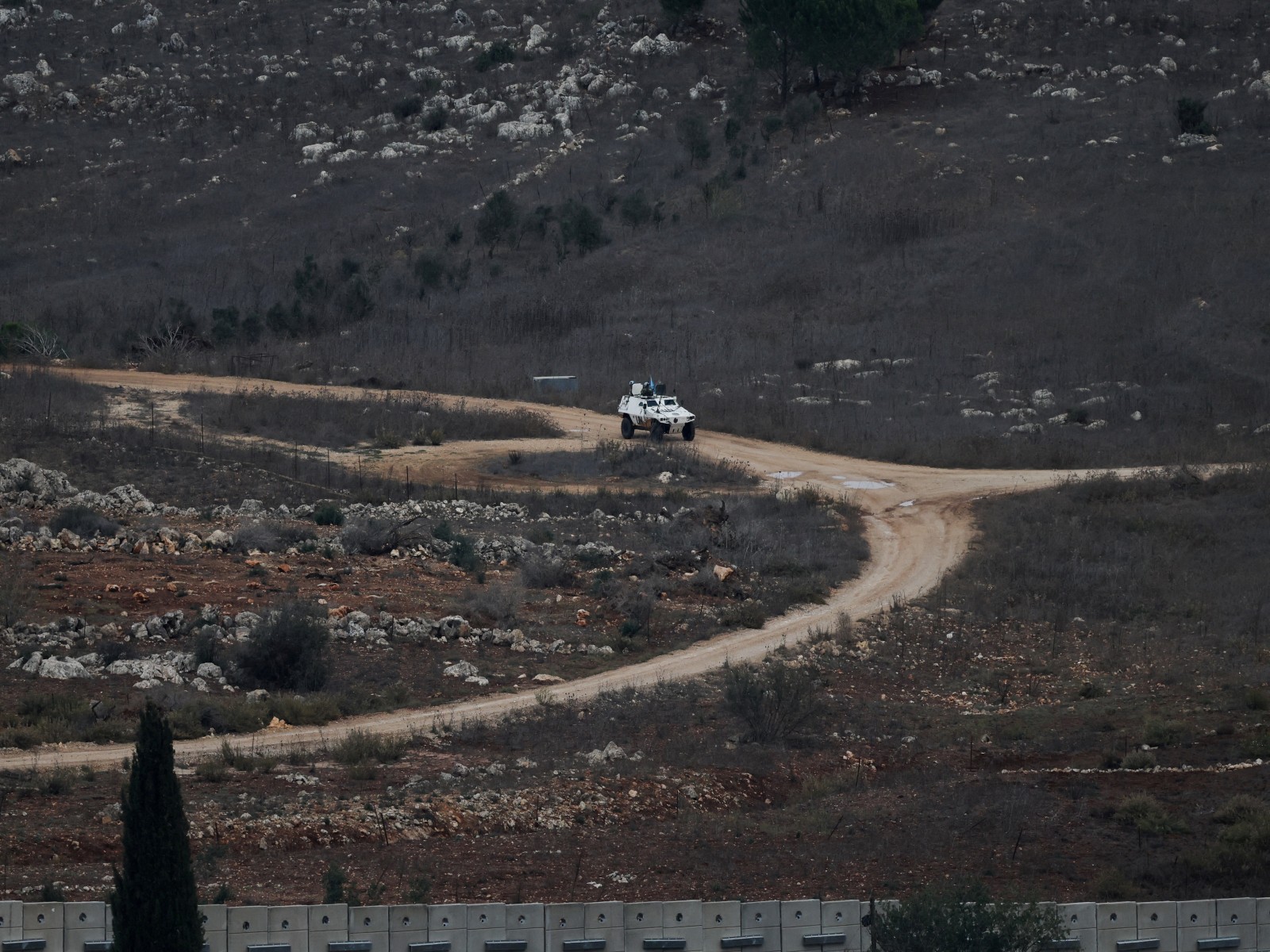 A UN vehicle drives near a concrete wall along Lebanon's southern border which, according to the Lebanese presidency, extends beyond the "Blue Line", a UN-mapped line separating Lebanon from Israel and the Israeli-occupied Golan Heights, as seen from
