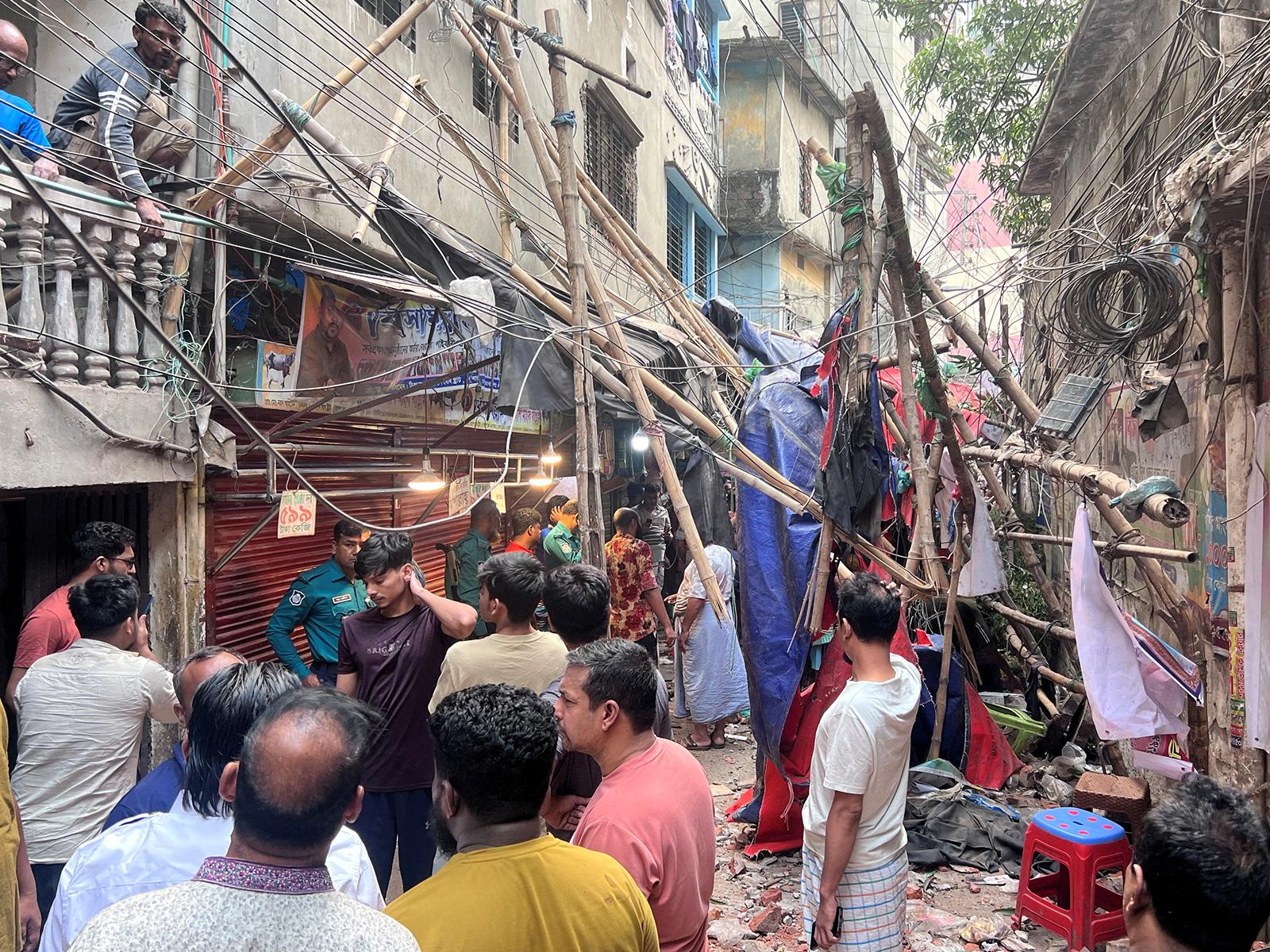 Residents stand in an alley after vacating their house next to a fallen scaffolding following an earthquake in Dhaka (Photo/Reuters)
