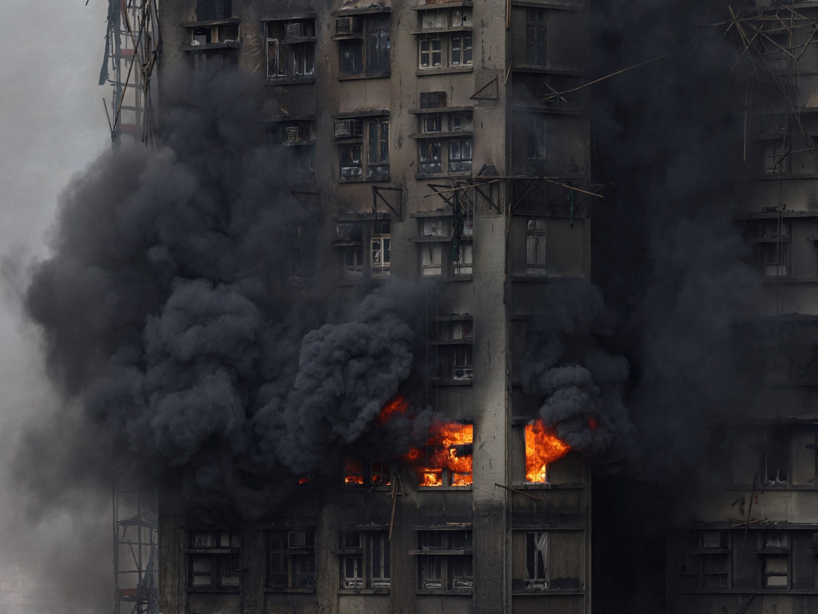 Thick smoke billows from the upper floors of a residential block at Wang Fuk Court housing estate during a major fire that engulfed bamboo scaffolding across multiple buildings, in Tai Po, Hong Kong (Photo/Reuters)