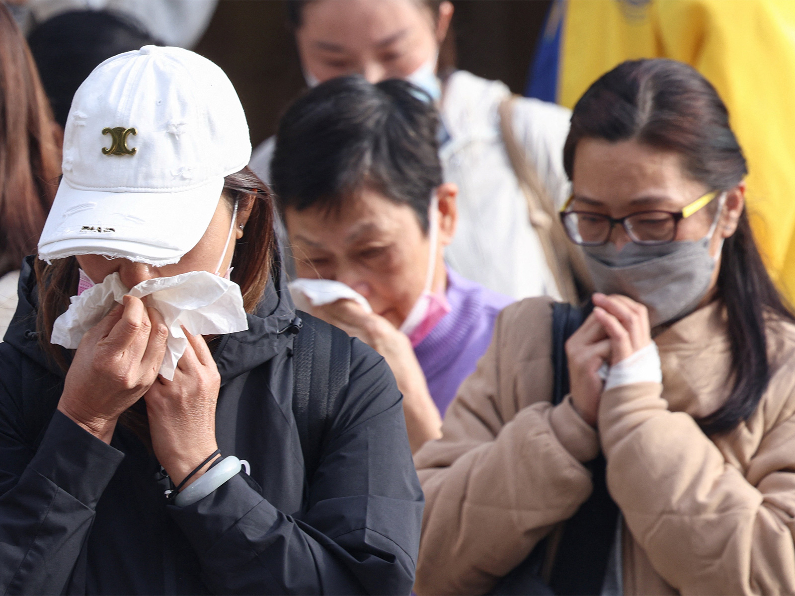 Relatives react after identifying family members from photos at Kwong Fuk Community Hall following the Wang Fuk Court housing estate fire, in Tai Po, Hong Kong (Photo/Reuters)