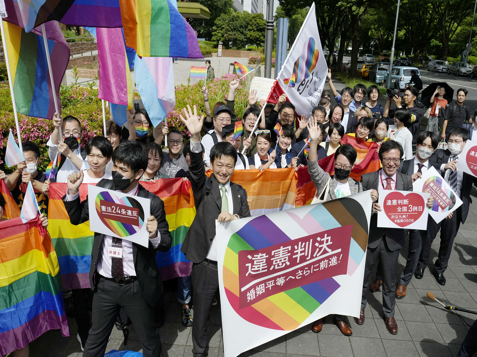 People, including the plaintiffs' lawyers, hold banners and flags outside the Nagoya District Court after the lower court ruled that the ban on same-sex marriage was unconstitutional, in Nagoya, central Japan. (Photo/Reuters)