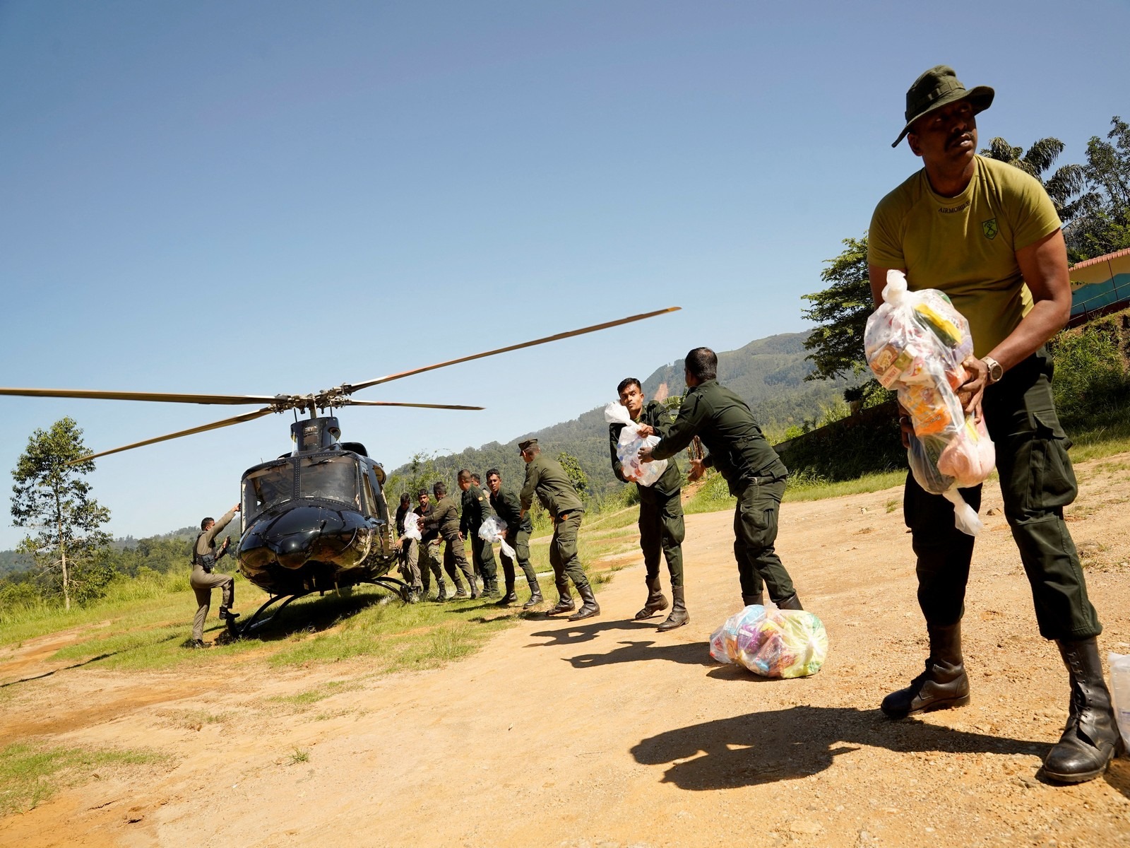 Sri Lanka Army soldiers unload relief material from a helicopter for flood victims following Cyclone Ditwah (Photo/ Reuters)