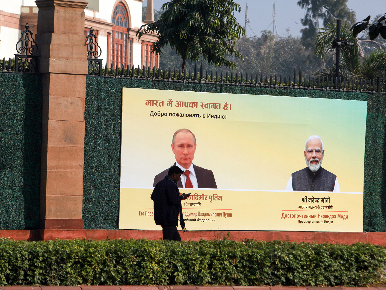 A man walks past a hoarding installed to welcome Russia's President Vladimir Putin to India on his visit, outside Hyderabad House, in New Delhi on Thursday. (Photo/ANI)