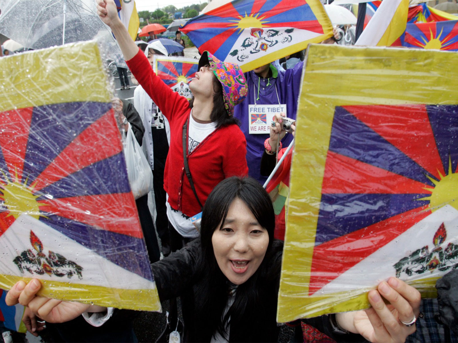 A pro-Tibet supporter holds placards displaying Tibetan flags during a demonstration in Japan (File Photo/ Reuters)