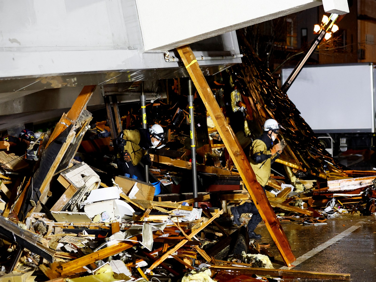 Rescue workers run out of a collapsed building after hearing an earthquake alarm, following an earthquake in Wajima, Ishikawa prefecture, Japan, January 3, 2024 (Photo/Reuters)