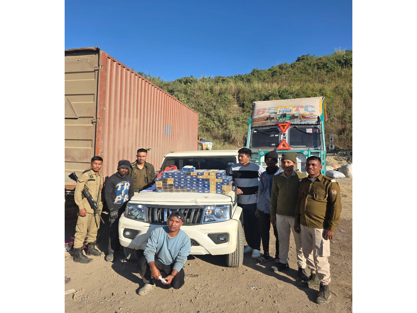 Police with seized cigarettes and heroin in Cachar district. (Photo/ANI)