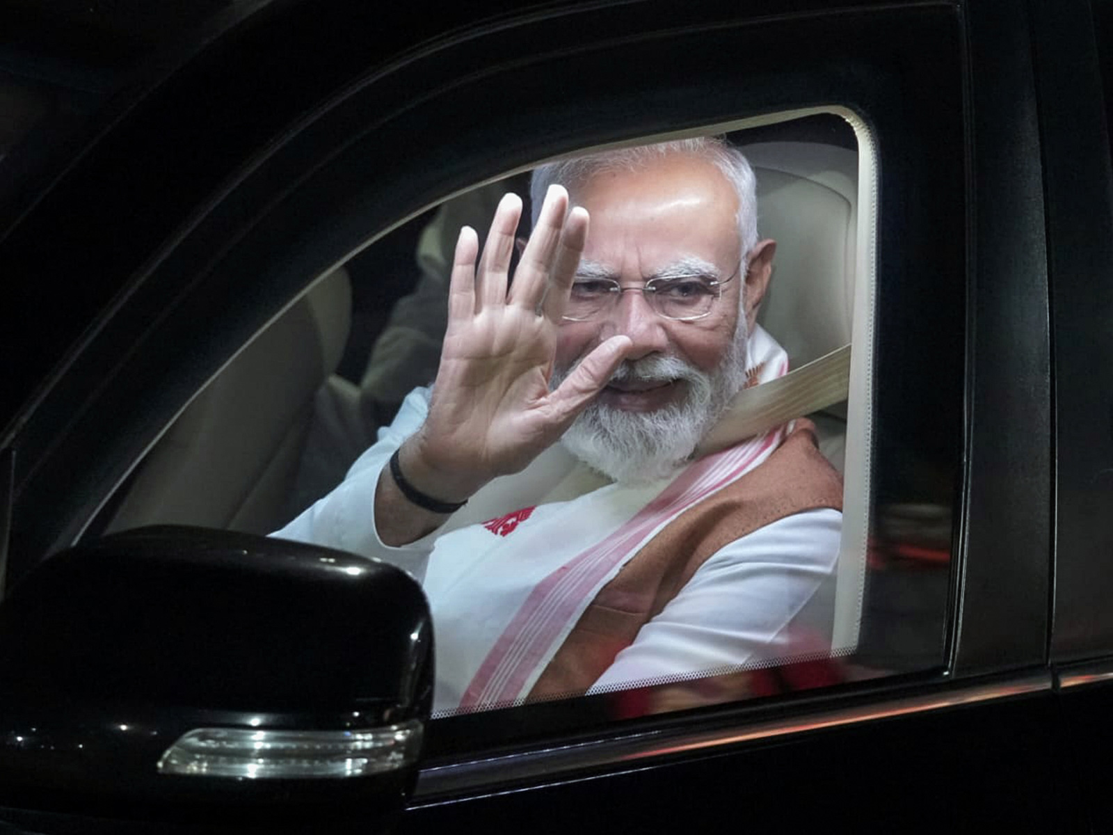 Prime Minister Narendra Modi waves during the roadshow, in Guwahati on Saturday. (@CMOfficeAssam/ANI Photo)