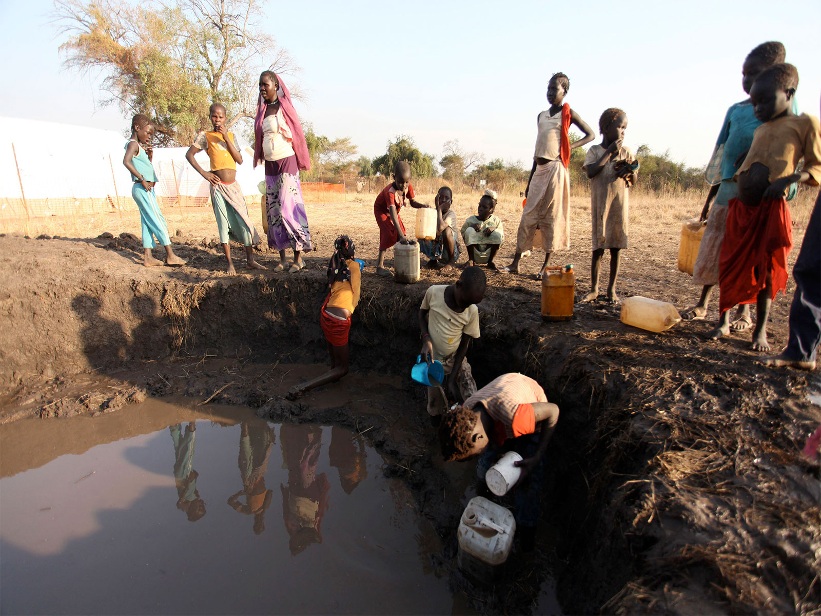 Sudanese from the war-torn Blue Nile state collect muddy water, in order to avoid the 12-hour queue at a water pump, in South Sudan's Doro refugee camp (Photo/Reuters)