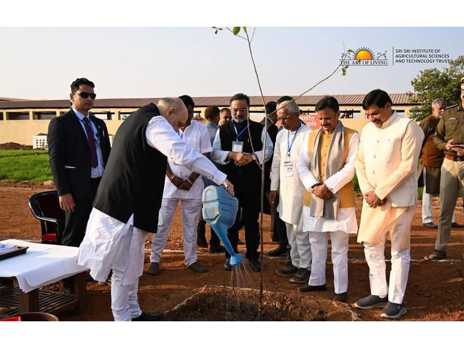 Hon'ble Union Home Minister Shri Amit Shah planting and watering a sapling at the Rewa Model Farm