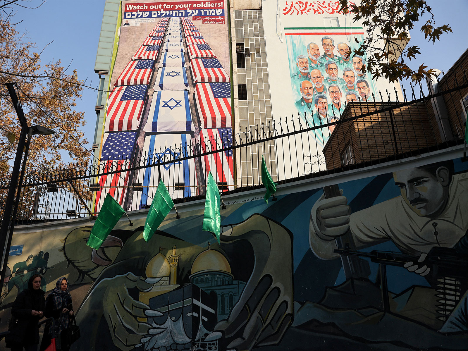 Women walk past an anti-US and anti-Israeli billboard displayed on a building in Tehran, Iran (Photo/Reuters)