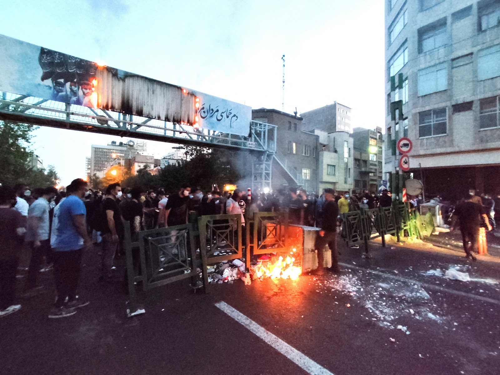 Protesters gather on a street in Iran as barricades burn during ongoing anti-government demonstrations, with security personnel deployed to control the situation (File Photo/Reuters)