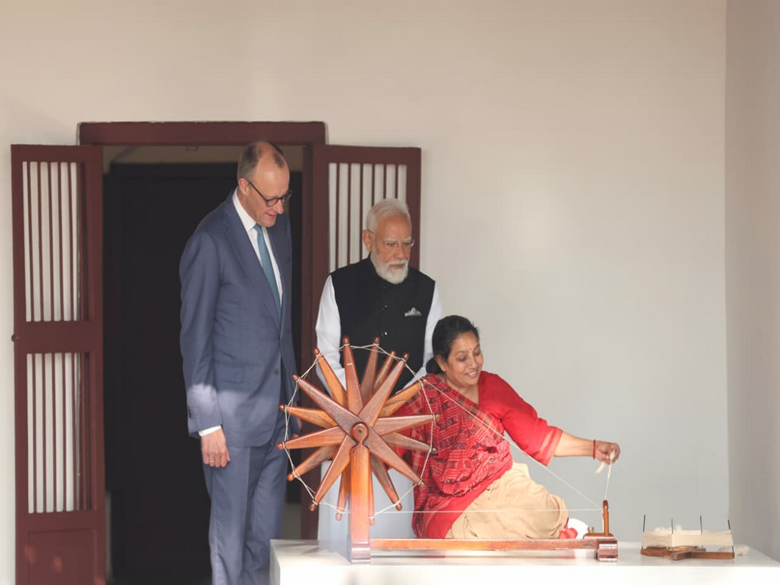 Prime Minister Narendra Modi and German Chancellor Friedrich Merz observing the process of spinning the charkha at Hridaykunj, Gandhiji's residence in the ashram (Photo: x/@CMOGuj)