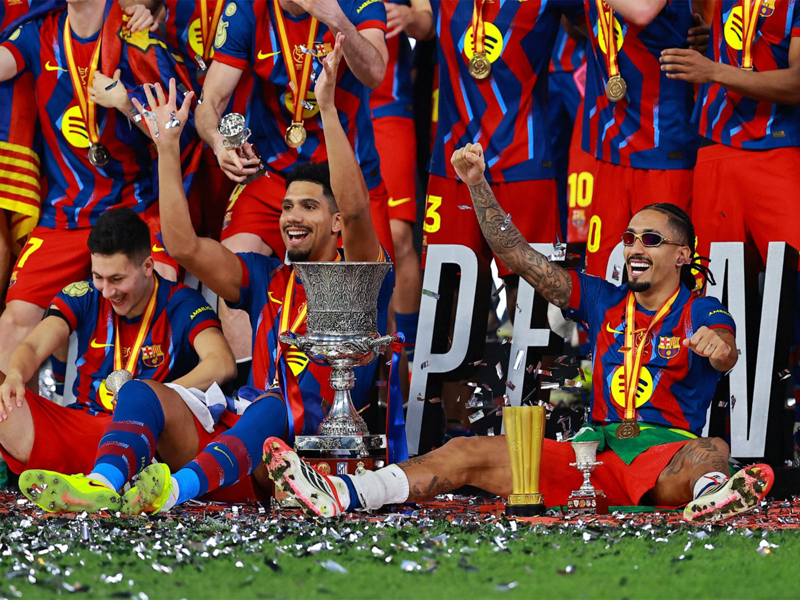 Raphinha celebrate with the trophies after winning the Spanish Super Cup final (Photo: Reuters)