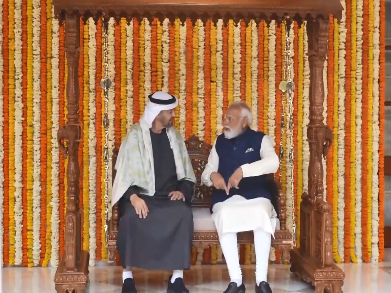 Prime Minister Narendra Modi and UAE President Sheikh Mohamed bin Zayed Al Nahyan sit on the Royal carved wooden Jhula gifted as part of traditional Indian presents during the UAE leader's official visit, at Lok Kalyan Marg in New Delhi. (Photo/ANI)