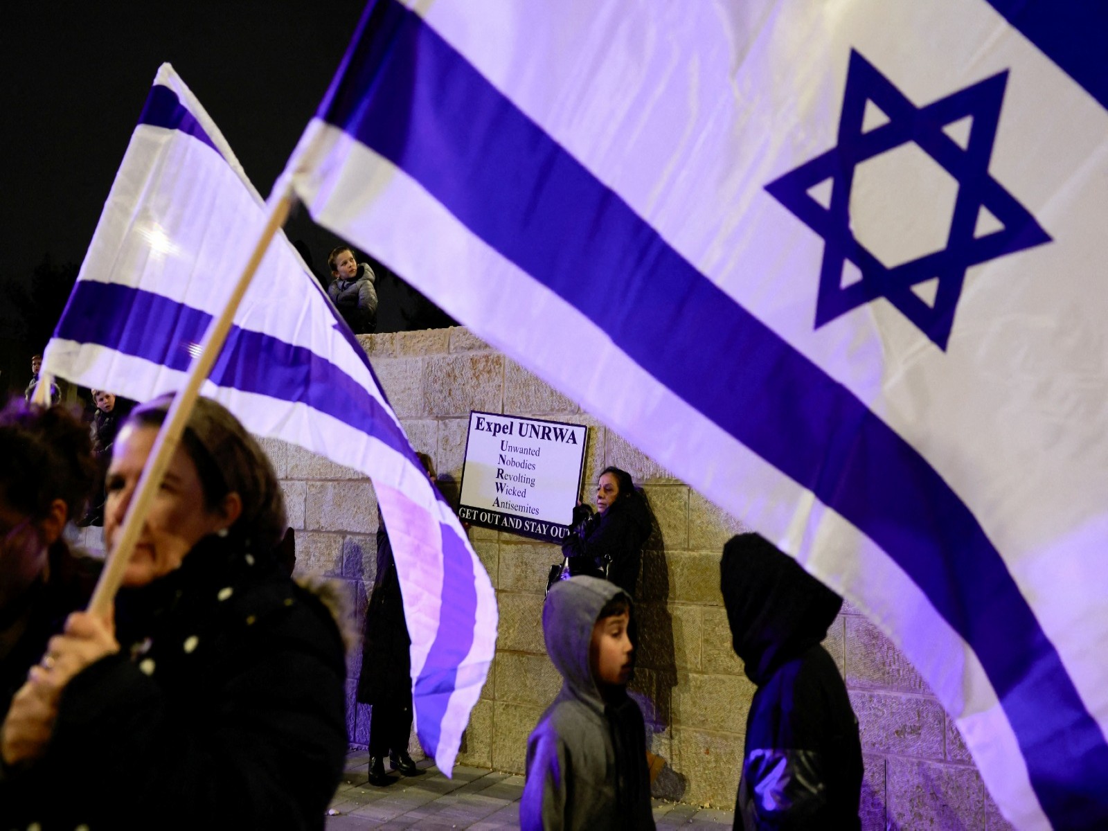 Israeli protesters hold flags as they demonstrate outside the UNRWA office in Jerusalem (File Photo/Reuters)