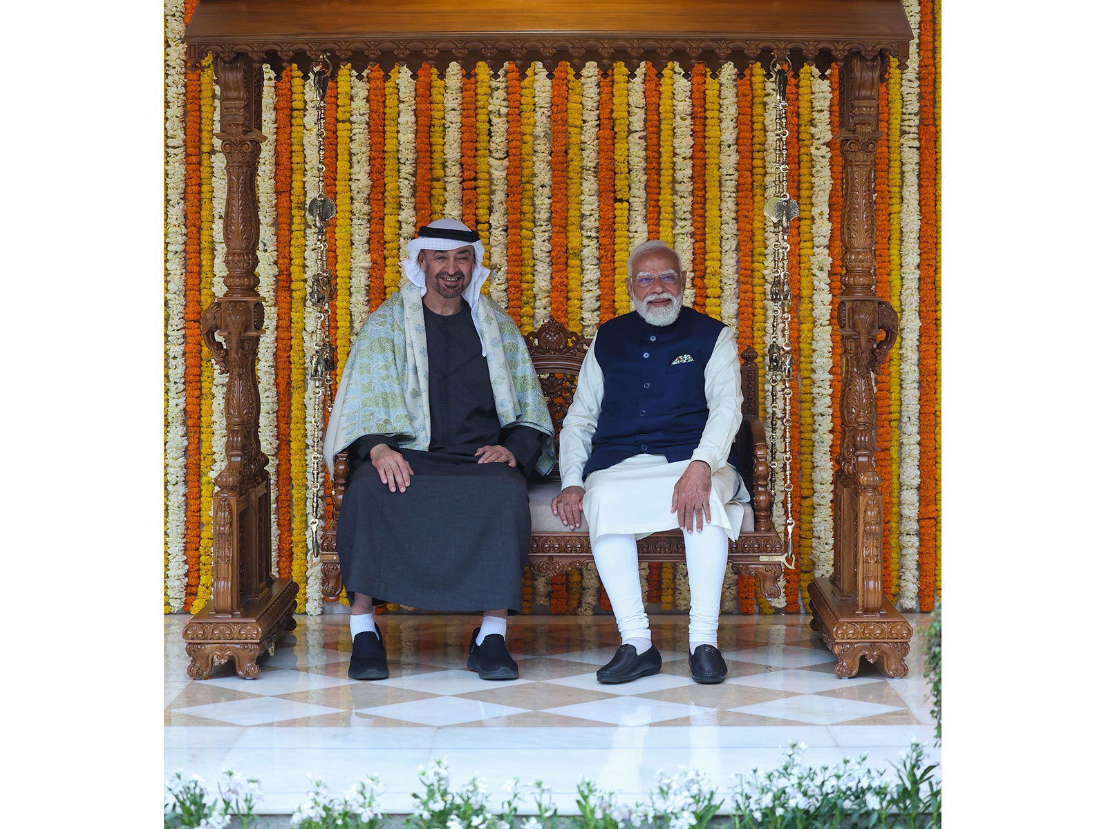 Prime Minister Narendra Modi and UAE President Sheikh Mohamed bin Zayed Al Nahyan sit on the Royal carved wooden Jhula gifted as part of traditional Indian presents during the UAE leader's official visit, at Lok Kalyan Marg in New Delhi (Photo/PMO)