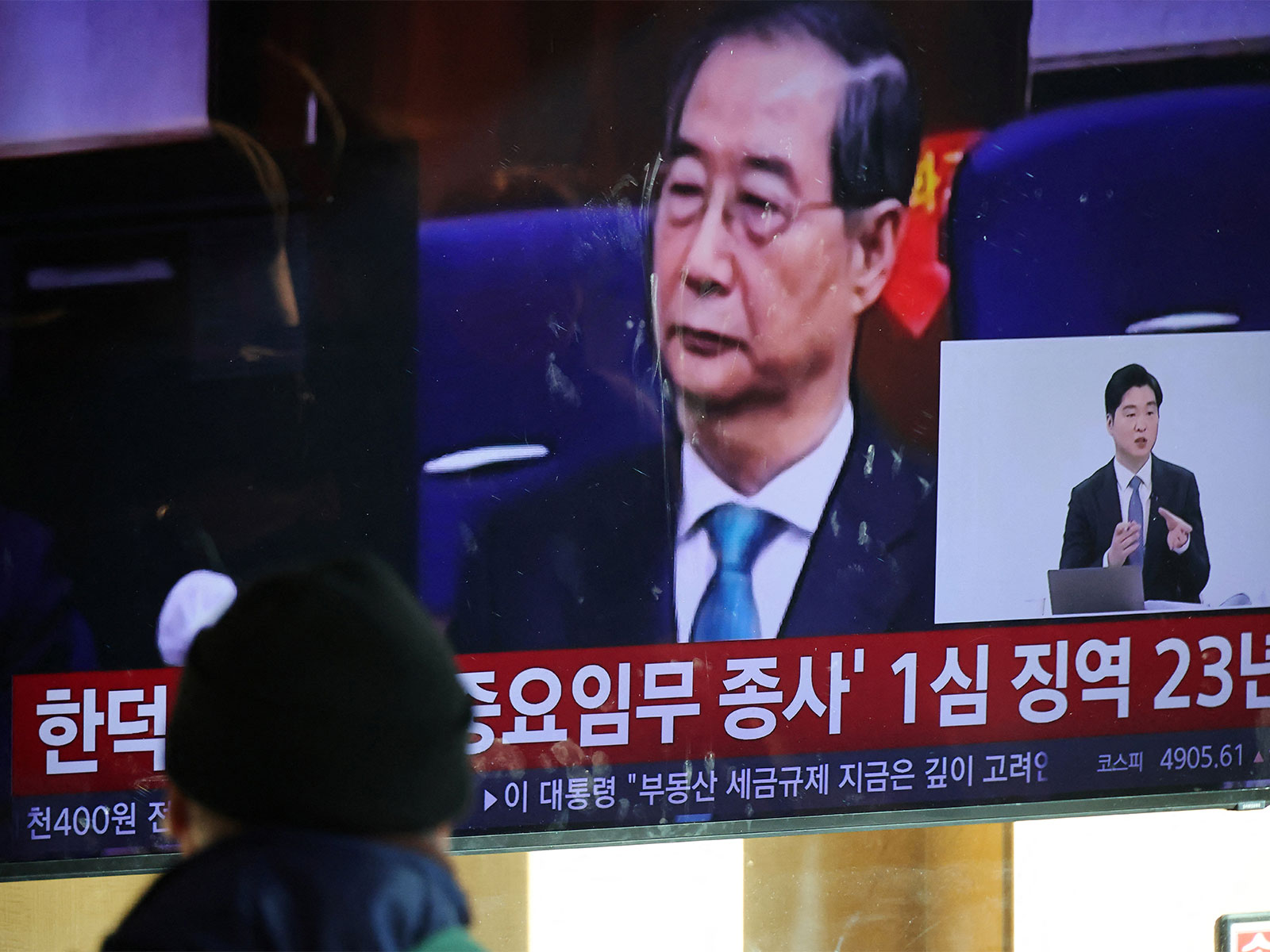 People watch news as S Korea's former PM Han Duck-soo gets 23 years jail in martial law case (Photo/Reuters)