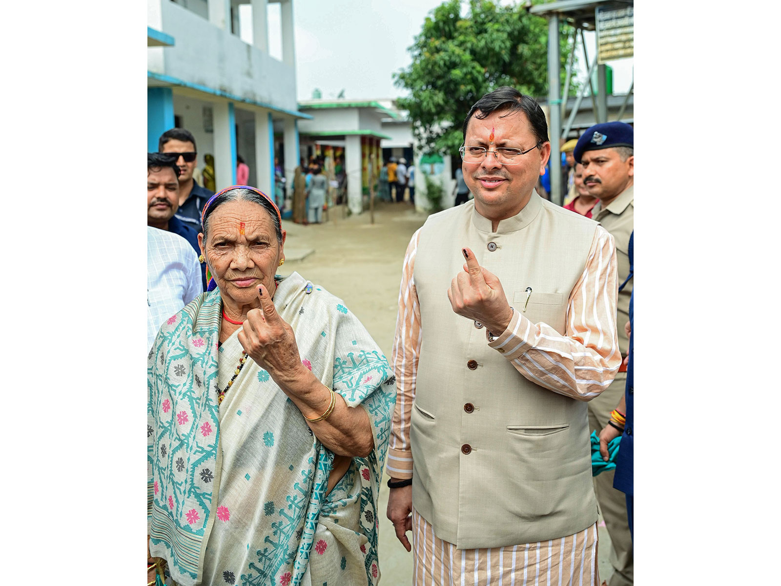 Uttarakhand Chief Minister Pushkar Singh Dhami and his mother Bishna Devi show their ink-marked fingers after casting their votes (File Photo/ANI)