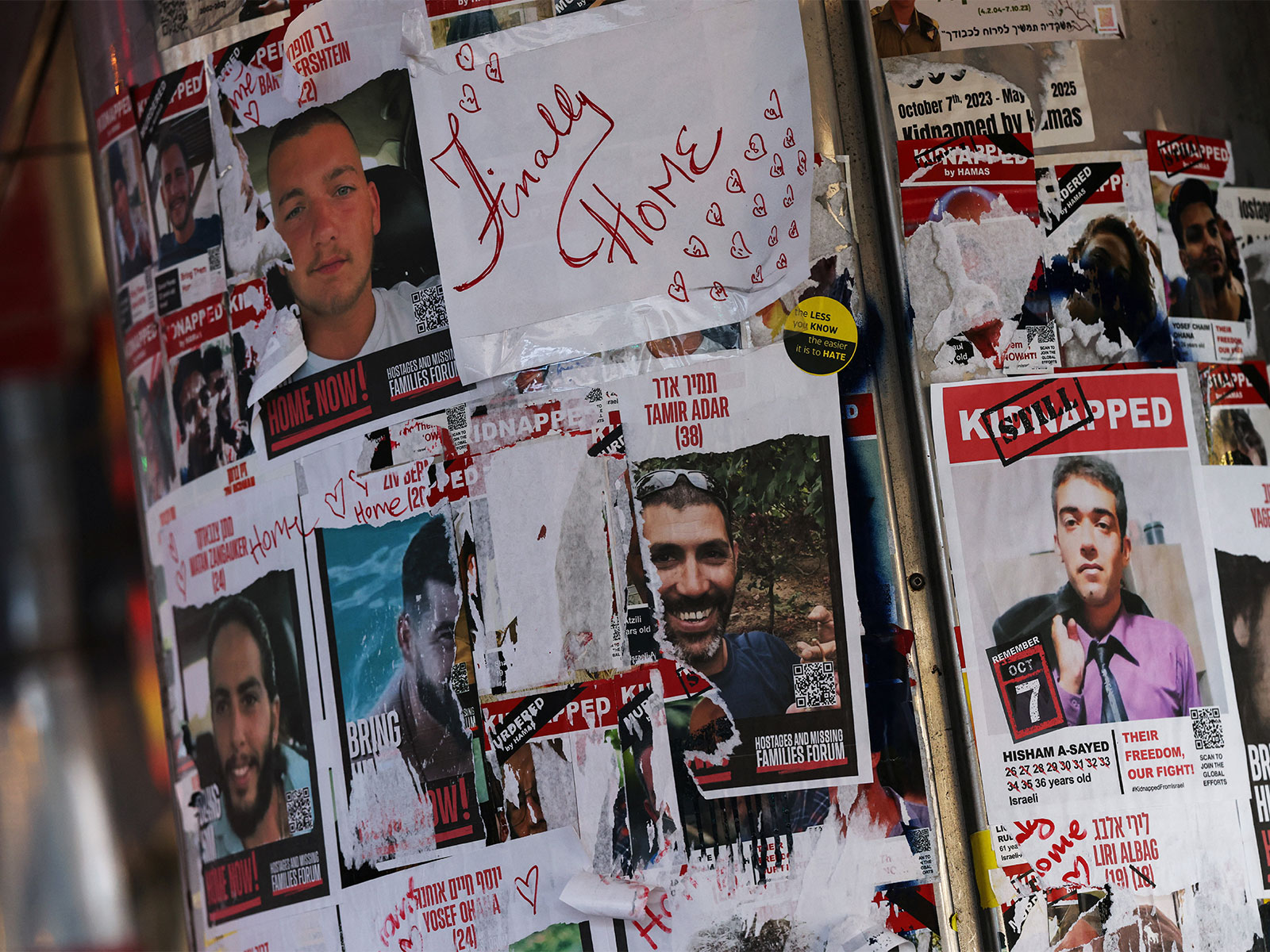 A sheet of paper reading "Finally Home" is stuck among posters of Israeli hostages kidnapped during Hamas's attack on Israel (Photo/Reuters)