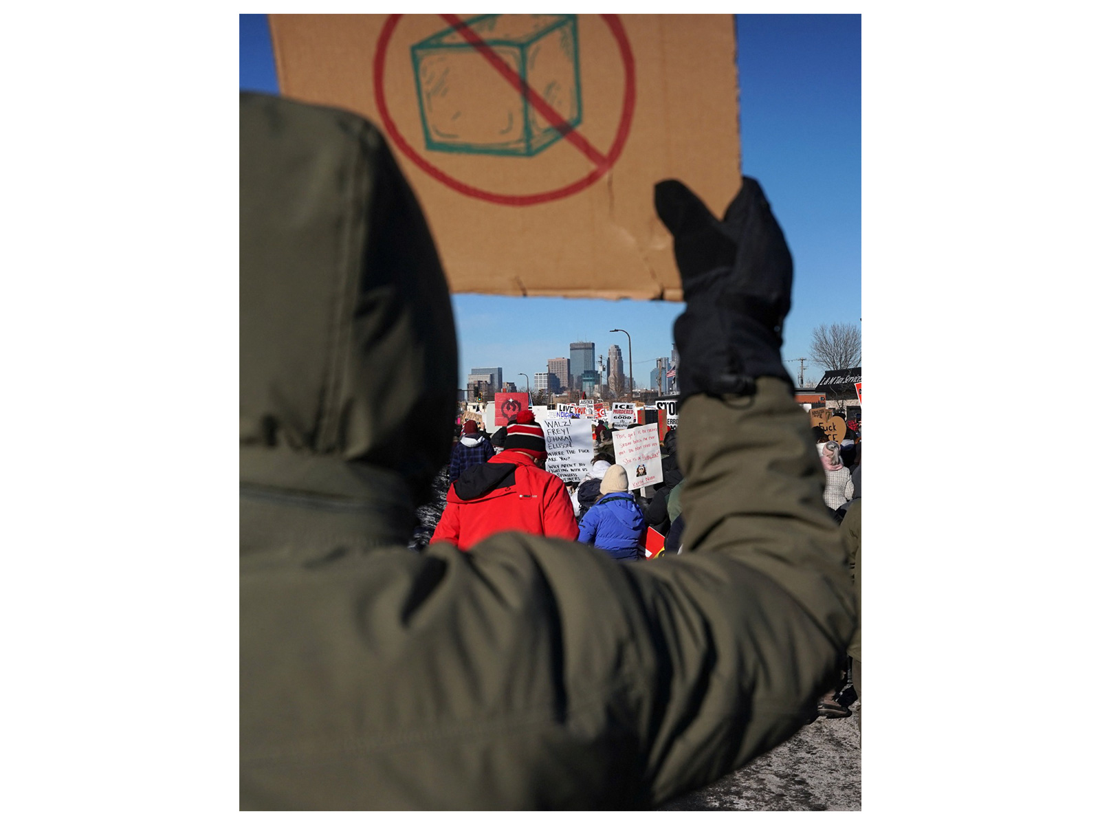 Protestor with "ICE Out" placards (Photo/Reuters)