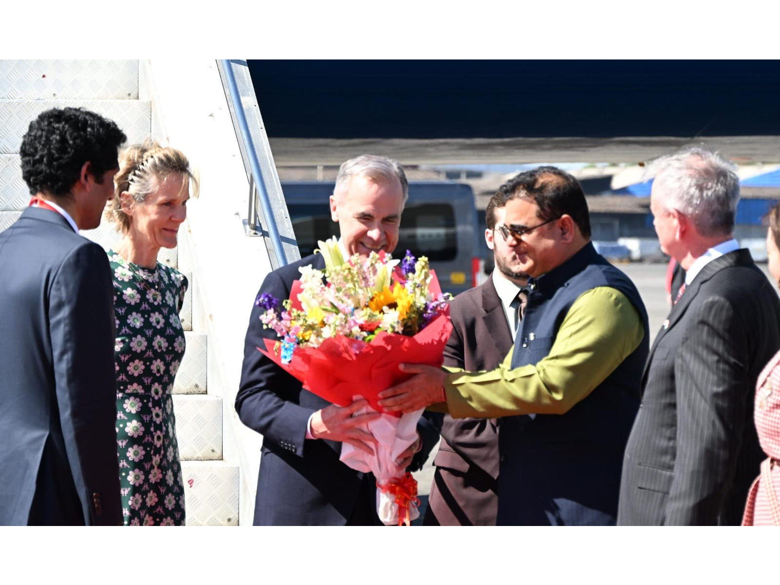 Canadian Prime Minister Mark Carney receives a bouquet upon arrival in Mumbai during his first official visit to India, accompanied by Diana Fox Carney. (Photo: X/@MEAIndia)